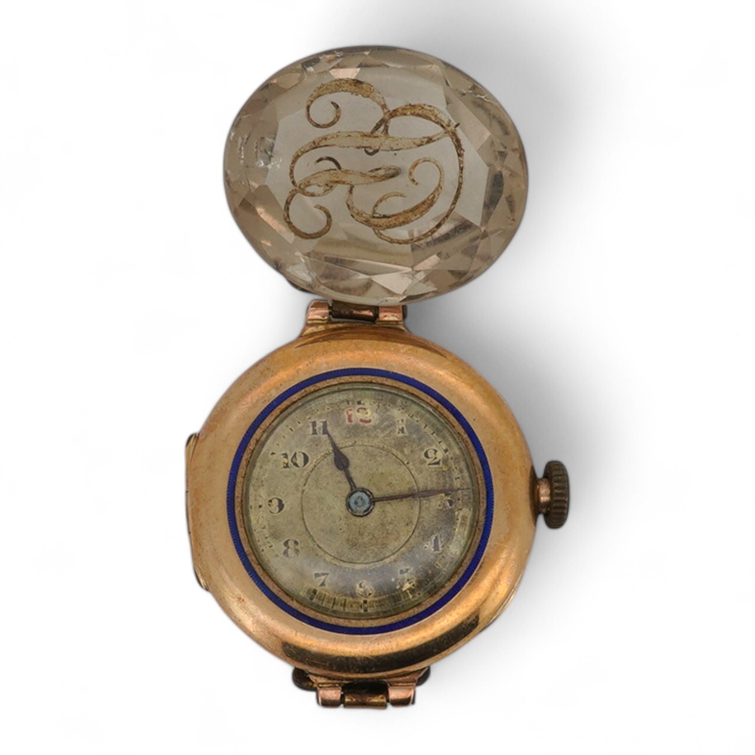 A lady's George V 9ct gold and enamel manual wind wrist watch, no strap, together with an unmounted oval cut quartz, carved with monogram, 19mm by 16mm.